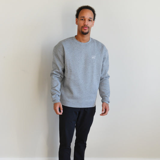 Man wearing a cozy gray crewneck sweater, showcasing stylish comfort and a relaxed fit.